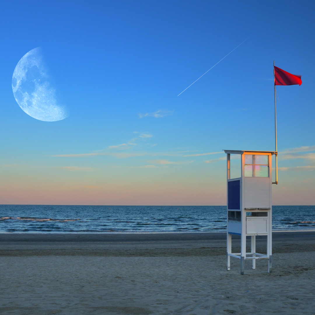 Ein verlassener Rettungsturm mit roter Warnflagge steht still am Strand, während der riesige Mond am Himmel hängt und ein Kondensstreifen leise eine Linie zieht. Das Bild wirkt wie ein eingefrorener Moment zwischen Ebbe und Flut – ein Sinnbild für das Ringen um Balance im Zeitmanagement: Die Flut der Aufgaben im Hintergrund, der Mond als stetiger Taktgeber der Zeit, die rote Flagge als Warnsignal vor Überlastung. Der Turm – Symbol für Überblick und Prioritäten – mahnt zur Ruhe und lädt ein, den eigenen Rhythmus neu zu justieren.